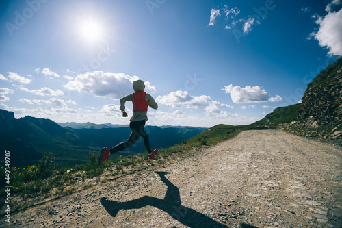 Young woman ultramarathon runner running at mountain top