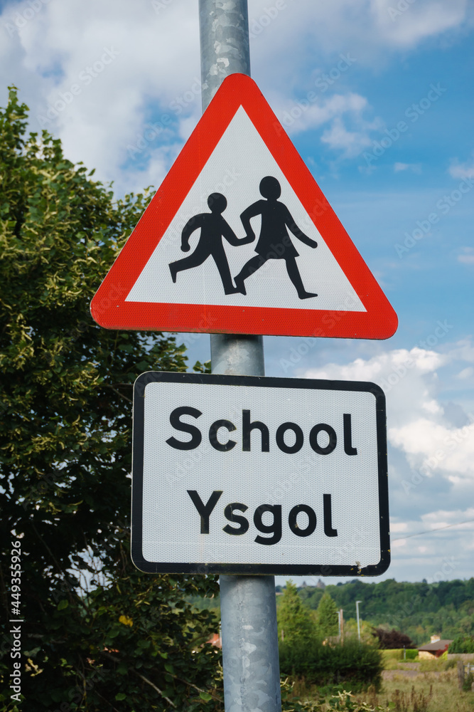 Bilingual school crossing warning sign in Welsh and English languages in rural North Wales UK