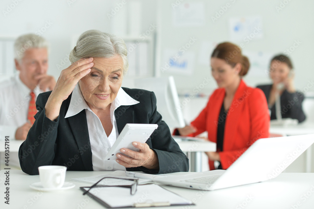 Business woman with a calculator in office