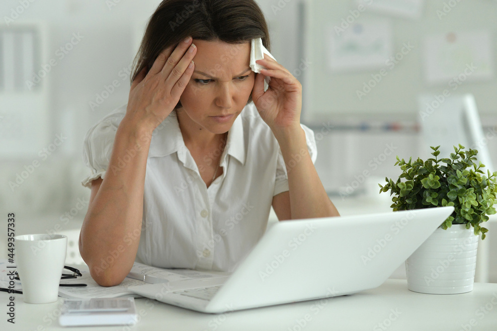 Young woman with headache in the office Young woman with headache in the office