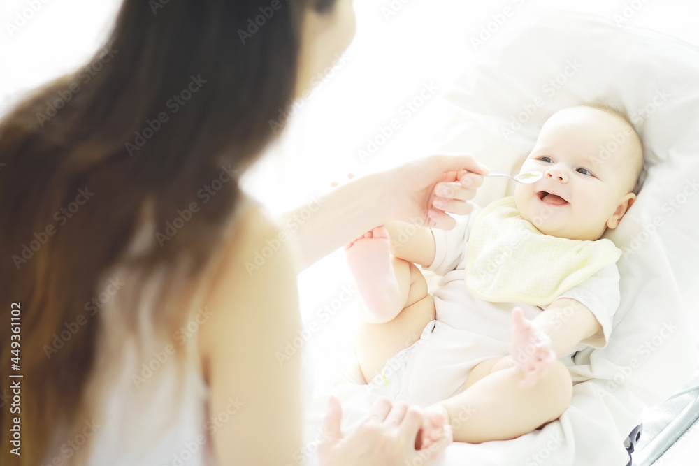 Maternity concept. A young mother feeds her little baby. First lure and breastfeeding. Family in white clothes. Maternity concept. A young mother feeds her little baby. First lure and breastfeeding. Family in white clothes.