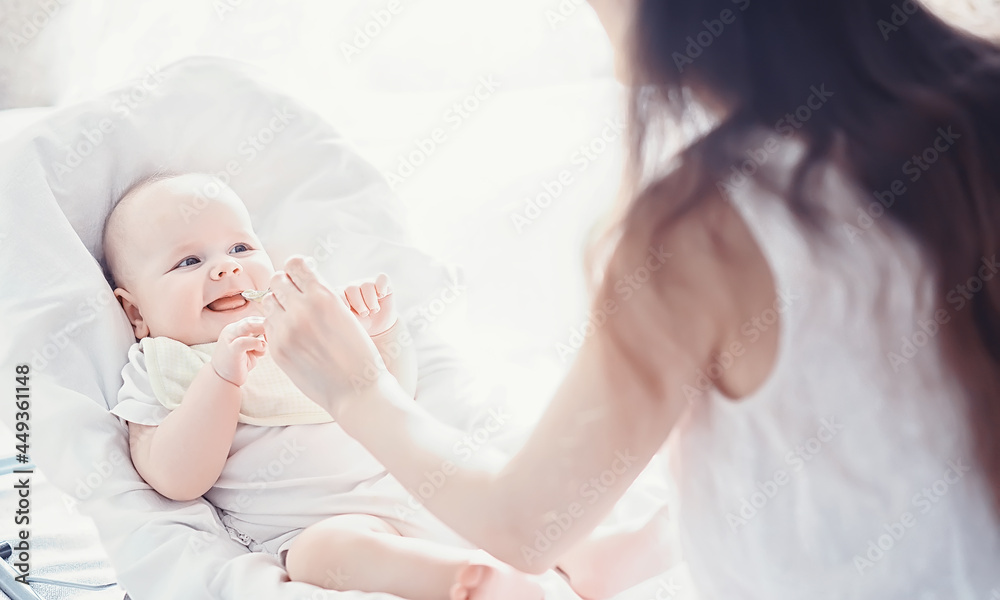 Maternity concept. A young mother feeds her little baby. First lure and breastfeeding. Family in white clothes. Maternity concept. A young mother feeds her little baby. First lure and breastfeeding. Family in white clothes.