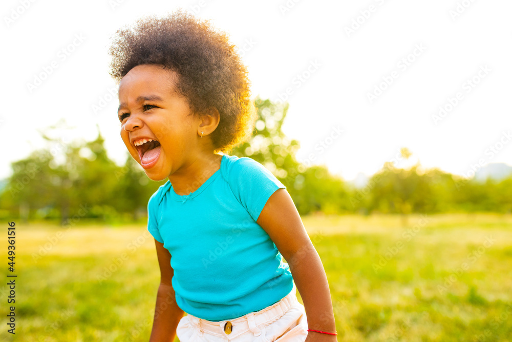 adorable small mixed race girl walking alone in park at sunset time adorable small mixed race girl walking alone in park at sunset time