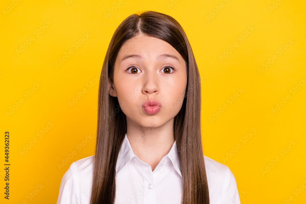 Fototapeta premium Photo of romantic affectionate schoolgirl send air kiss wear white shirt isolated yellow color background