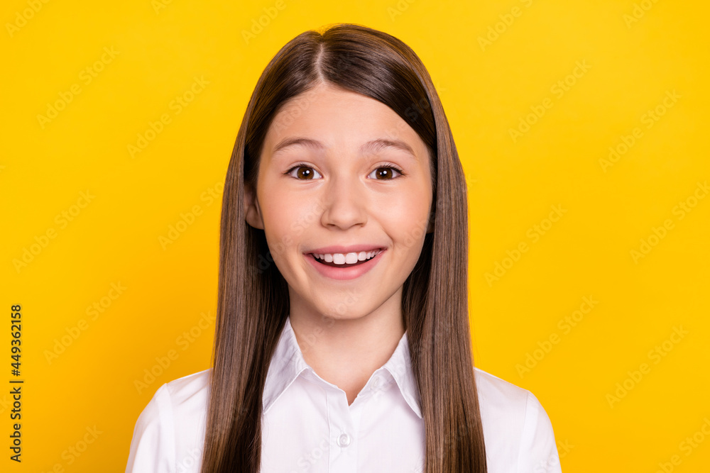 Photo of cute adorable excited schoolgirl beaming smile wear white shirt isolated yellow color background Photo of cute adorable excited schoolgirl beaming smile wear white shirt isolated yellow color background