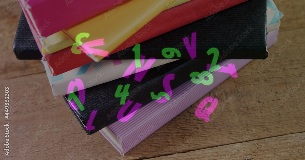 Obraz premium Digital composition of multiple changing alphabets and numbers floating against stack of books on wo