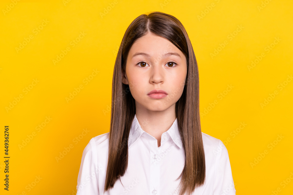 Photo of calm focused serious cute schoolgirl look camera wear white shirt isolated yellow color background Photo of calm focused serious cute schoolgirl look camera wear white shirt isolated yellow color background