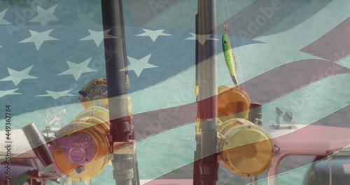 American flag waving against close up view of two fishing rod on a boat