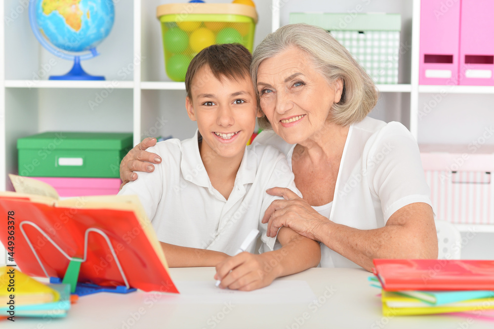 Granny with her grandson doing homework at home Granny with her grandson doing homework at home