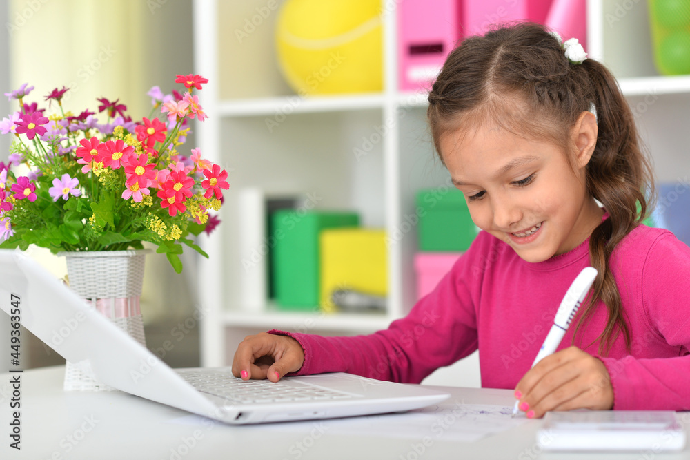 Porait of cute girl using laptop at home at desk Porait of cute girl using laptop at home at desk
