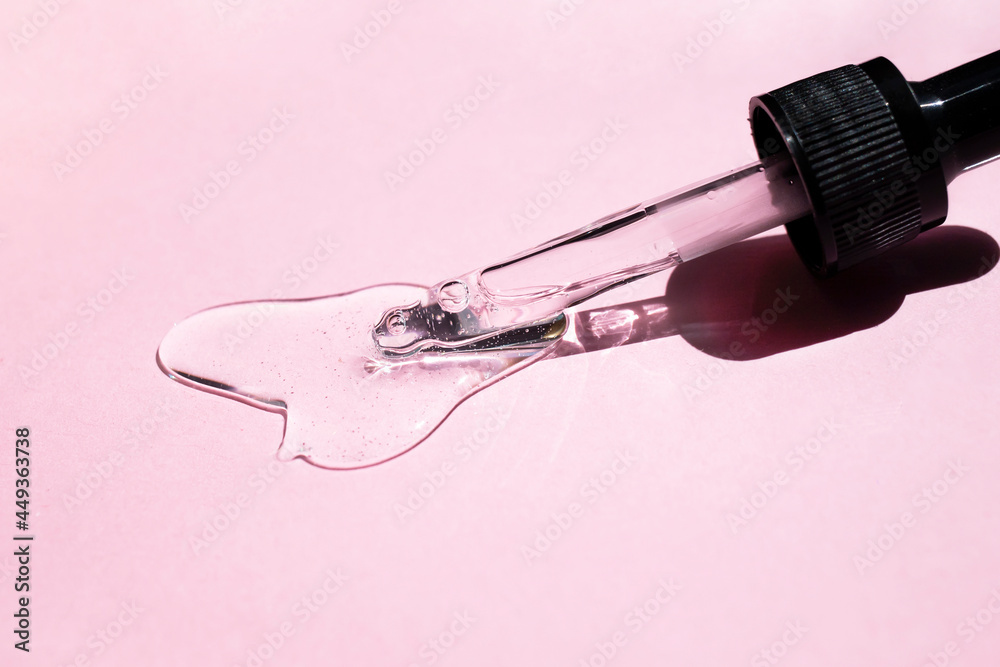 Hyaluronic acid with a dropper on a pink background. Side view. Hyaluronic acid with a dropper on a pink background. Side view.