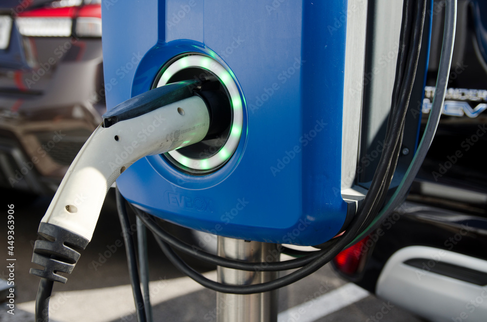 Madrid, Spain. 6th August. EV Car or Electric vehicle at charging station cable supply with blue energy power effect. Eco-friendly sustainable energy concept. Madrid, Spain. 6th August. EV Car or Electric vehicle at charging station cable supply with blue energy power effect. Eco-friendly sustainable energy concept.