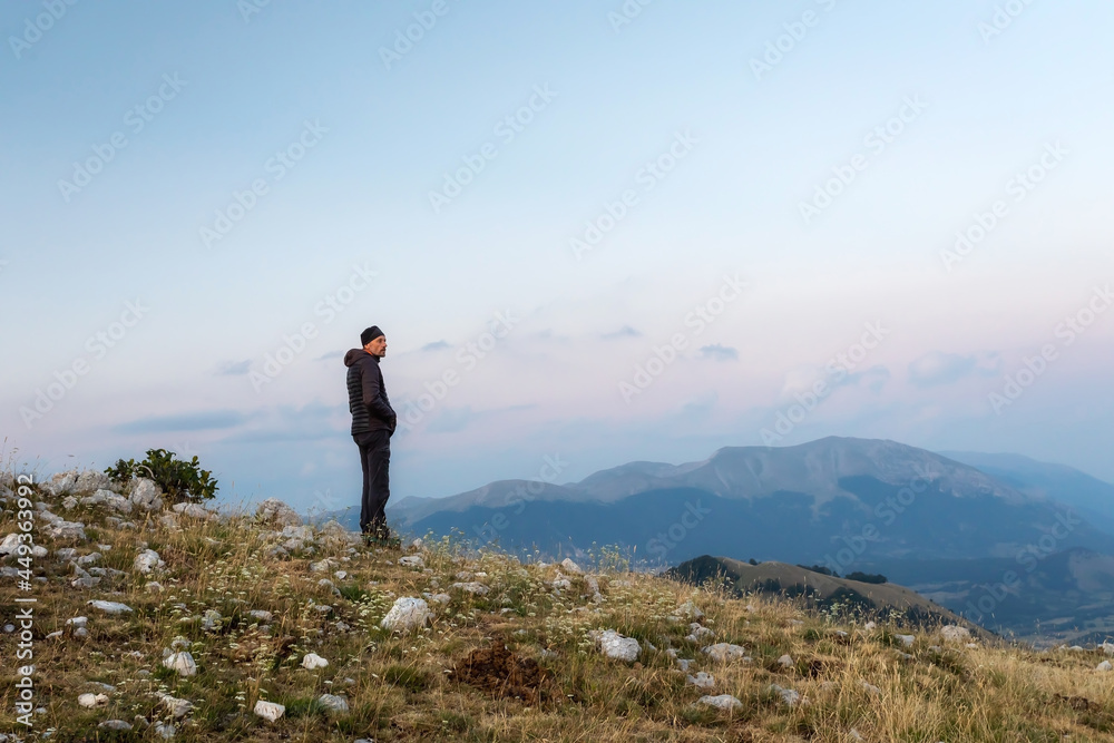 Hiker meditates amidst the mountain landscape.
