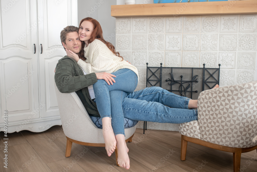 Happy woman hugging man near fireplace at home
