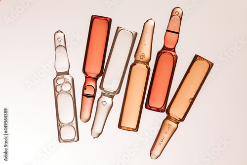 ampoules with different color serum on light background.