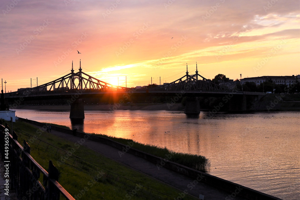 Urban landscape and a beautiful sunset in the evening on the river with a bridge in the background. Copy space