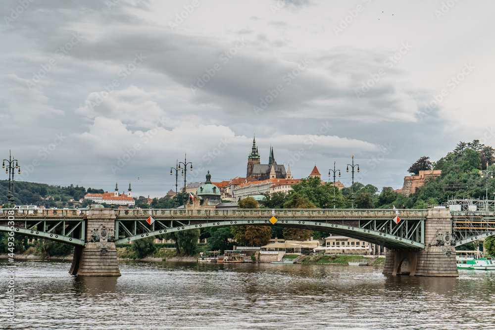 Fototapeta premium Scenic panorama of beautiful Prague Castle,Saint Vitus cathedral,Cechuv bridge over Vltava river.Famous tourist destination.Prague panorama on cloudy summer day.European cityscape urban travel concept