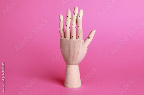 Wooden hand model on pink background. Mannequin part photo