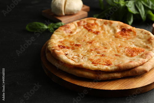 Delicious khachapuri with cheese on black table, closeup