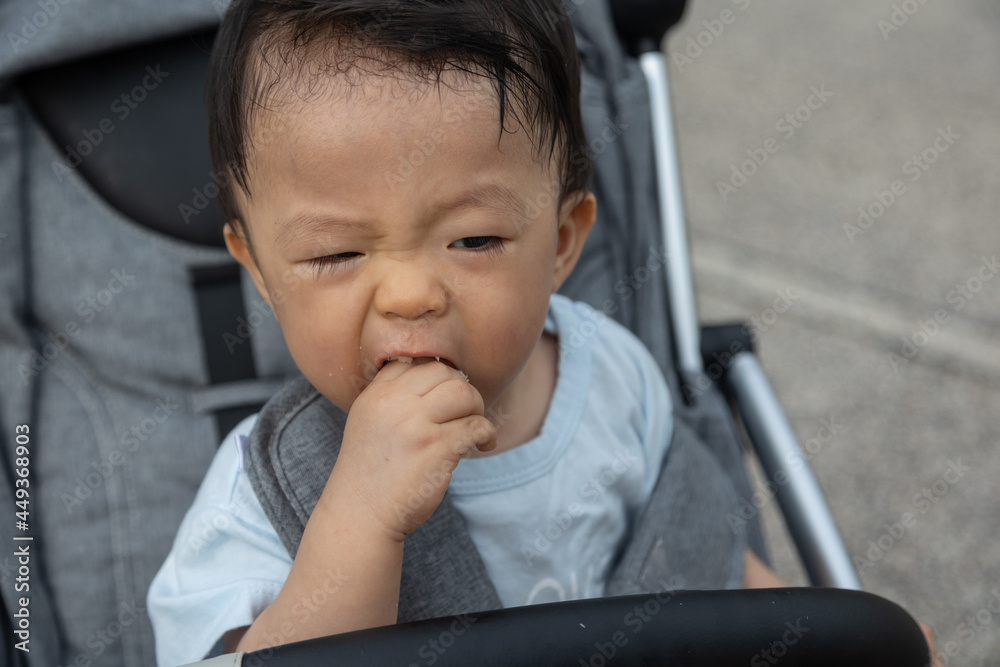 Closeup portrait image of Happy and cute Asian Chinese baby boy sitting on stroller at park during evening Closeup portrait image of Happy and cute Asian Chinese baby boy sitting on stroller at park during evening