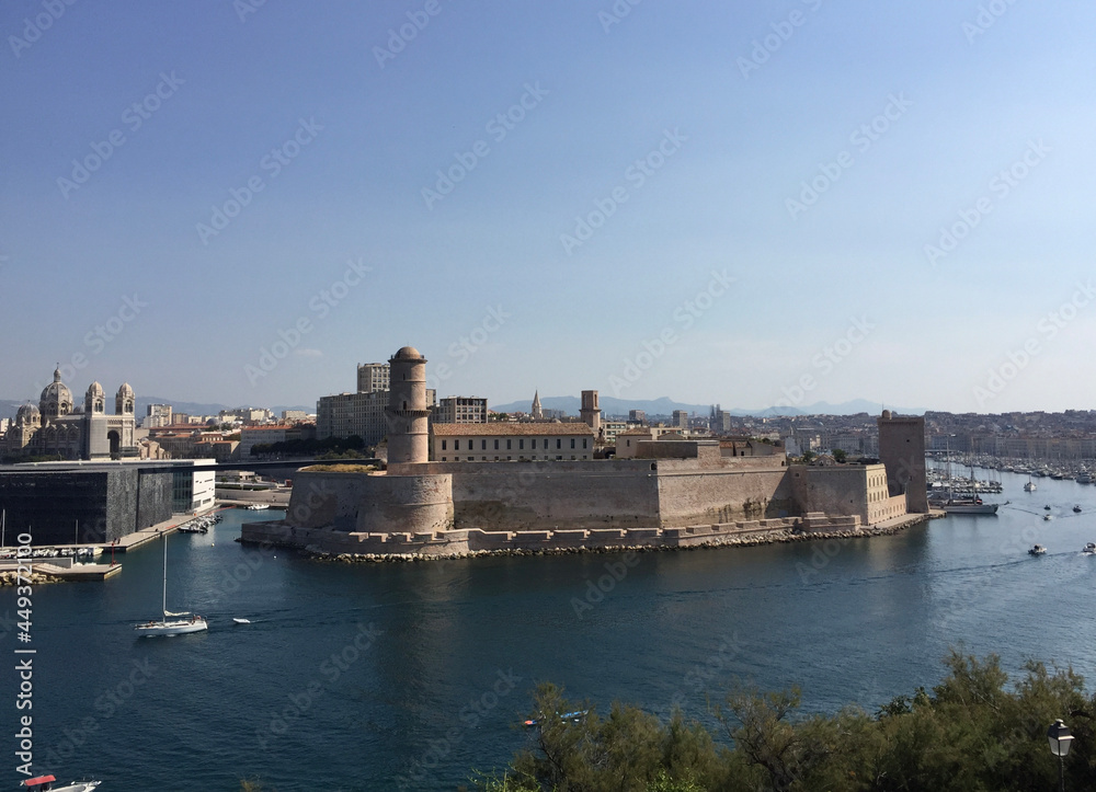 Panoramic view of Fort Saint-Jean with Marseille Cathedral and Mucem museum on the left and the entrance to the Old Port to the right, seen from the Pharo Palace in Marseille, France.