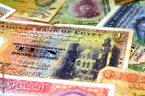 Selective focus of old Egyptian pounds and piasters money banknotes background at the time of the Kingdom of Egypt and Sudan with an Image of king Farouk I, King Tutankhamen and Egyptian landmarks photo