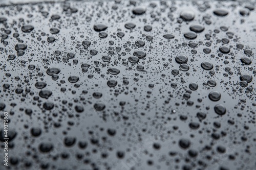 Wet metal surface after rain. Hydrophobic effect and water drops on car varnish after using ceramic coating