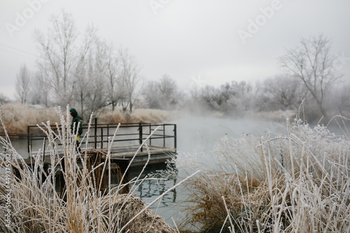 Fisherman on a dock on a cold winter morning in Nampa, Idaho photo