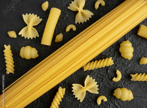 Raw pasta varieties on black background