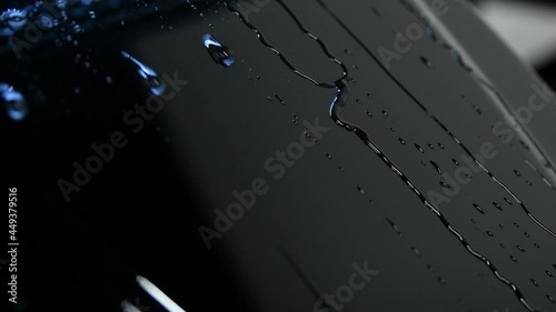 Video showing advantages of using ceramic coating on mini car hood. Hydrophobic effect on water pouring on metal surface