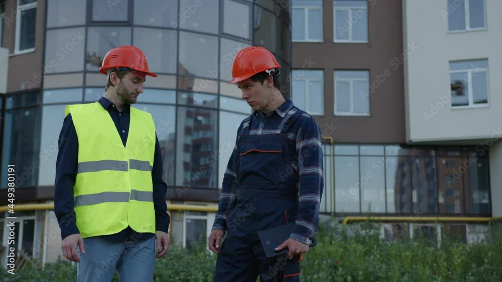 Front view of a two builders who stand outside