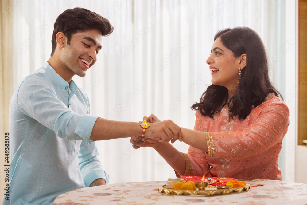 A HAPPY BROTHER SISTER ENJOYING RAKSHABANDHAN RITUALS A HAPPY BROTHER SISTER ENJOYING RAKSHABANDHAN RITUALS