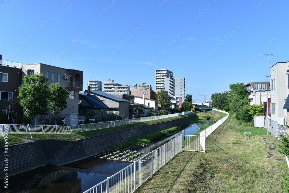 Sapporo Japan August 1 2021 The peaceful neighboring landscape landscape along with the small canal with the clear blue sky in Sapporo Japan