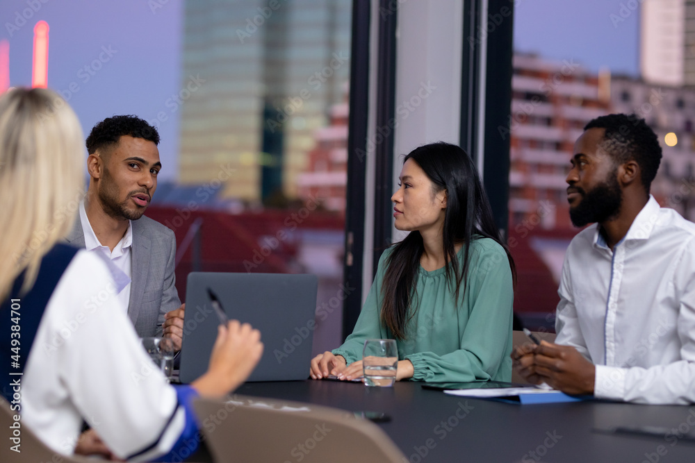 Diverse group of business colleagues working at night having meeting Diverse group of business colleagues working at night having meeting