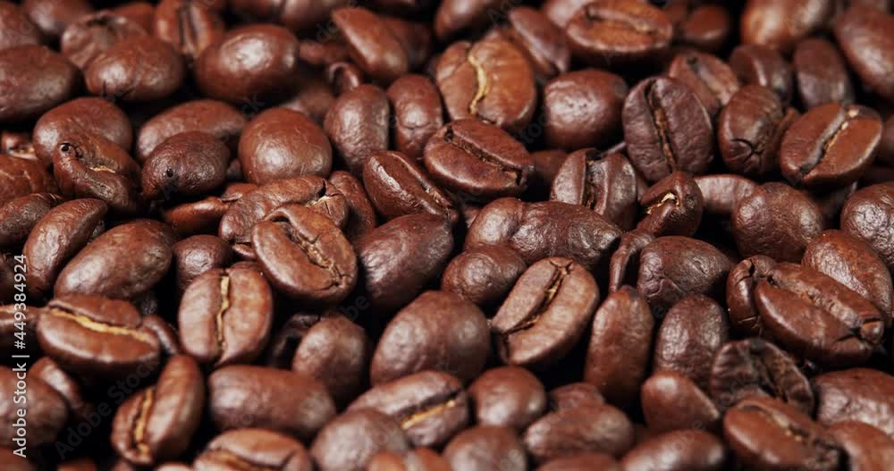 Roasted coffee beans dolly shot. Aromatic coffee beans move slowly. Slide slow motion close-up of whole roasted coffee beans. Roasted coffee beans dolly shot. Aromatic coffee beans move slowly. Slide slow motion close-up of whole roasted coffee beans.