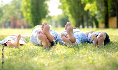 Family of four lying on the grass showing their feet to the camera