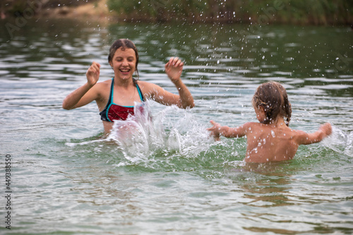 happy cheerful girls teenager splashes in water on vacation, horizontal