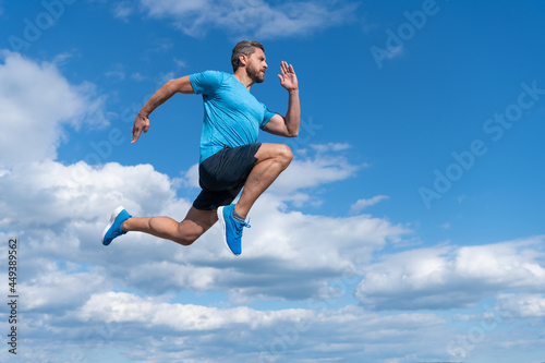 energetic man athlete with muscular body run in sportswear outdoor on sky background, endurance