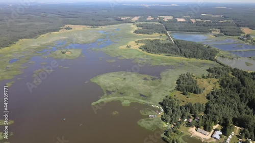 A bird's-eye view of the Siemianówka dam reservoir in the upper Narew valley.A bird's-eye view of two water pools separted track connected by a bridge.  photo