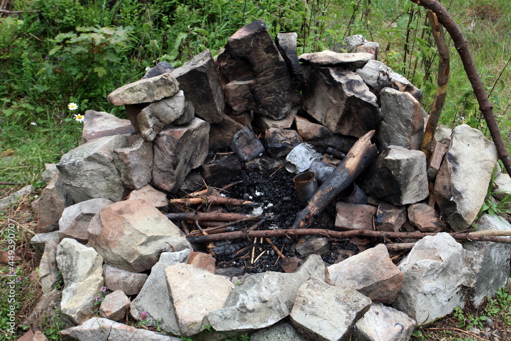 Old burnt fireplace. old abandoned bonfire in a meadow grass