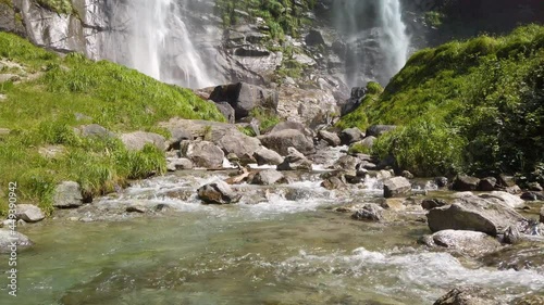 Water stream running from the beautiful Acquafraggia waterfall in Piuro, in the Bregaglia valley in Italy, before the ascent to the Maloja pass. It is a beautiful sunny summer day. photo