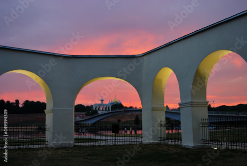 Shopping arcade on Yaroslav's Courtyard in the light of lanterns and against the backdrop of the sunset sky and the Novgorod Kremlin. Veliky Novgorod. Russia.