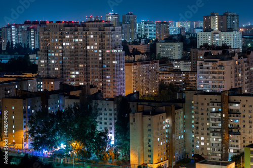 Night cityscape, lights from the windows of houses, stars in the sky, sleeping area. High quality photo