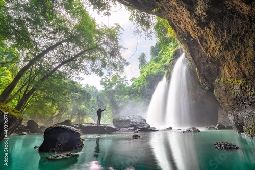 Tourist trekking to see the amazing of Haew Suwat Waterfall. Unseen Khao Yai National Park, Thailand. Tourists trekking see waterfall in tropical rainforest. Hiking nature trail, traveling ecotourism. photo