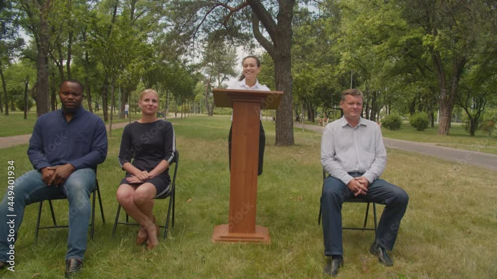 Lovely female university professor standing at lectern, giving
