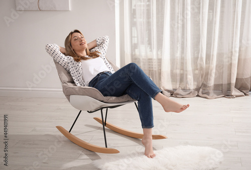 Fotografi Beautiful young woman sitting in rocking chair at home
