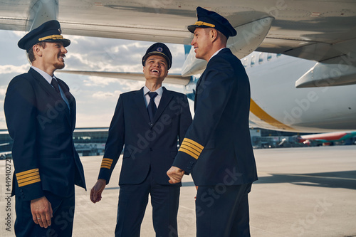 Three airline pilots enjoying each other company Fototapet