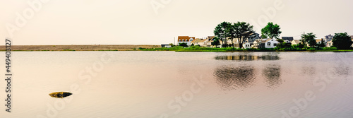 Tranquil seascape with a view of a zen-like rock and beach village on the sandbar peninsula