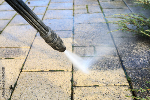 Wallpaper Mural Cleaning dirty paving stones in the garden with a pressure washer