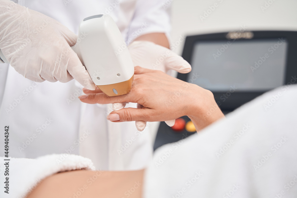 Woman doing laser epilation in professional salon